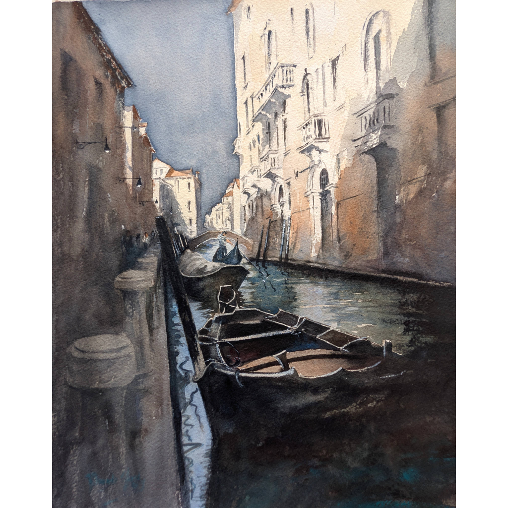 Evening lights shining on building in a Venice canal with boats in the shadows.